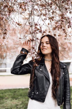 Çiçek açan ağaçta güzel bir kızın fotoğrafı çekiliyor.