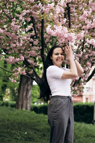 Çiçek açan ağaçta güzel bir kızın fotoğrafı çekiliyor.