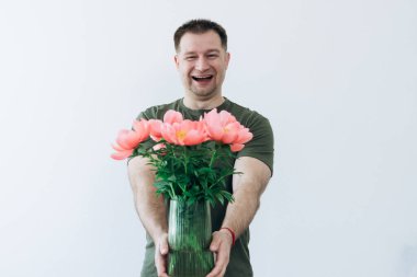 Adamın elinde şakayık vazosu var.