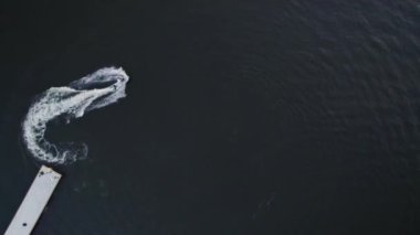 Yaz tatili, adam su motosikleti sürüyor ve akrobatik hareketler yapıyor.