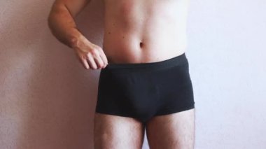 Siyah iç çamaşırlı ve gövdesi çıplak bir adam kendine masaj yapıyor. Erkek Sağlığı