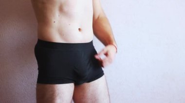 Siyah iç çamaşırlı ve gövdesi çıplak bir adam kendine masaj yapıyor. Erkek Sağlığı