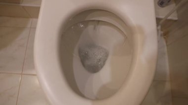Su, dışkıladıktan sonra beyaz tuvaletten aşağı atıldı.