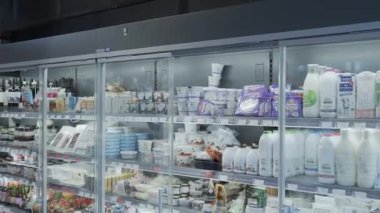 Süpermarkette alışveriş, mallarla birlikte. Ürünleri olan raflar 