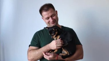 Erkeksi adam kucağında küçük bir Chihuahua köpeği tutuyor. Efendi ve evcil hayvan