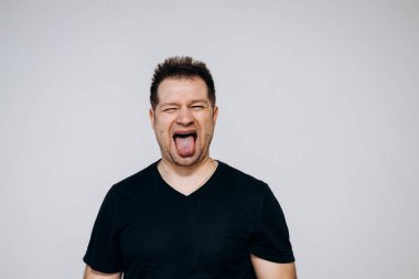 Siyah tişörtlü bir adam etrafta dolanıyor ve kamerada kıvranıyor.