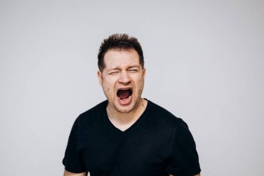 Saldırgan bir adam sinirlenir ve kamerayı yumruğuyla tehdit eder. Üzgün adam.