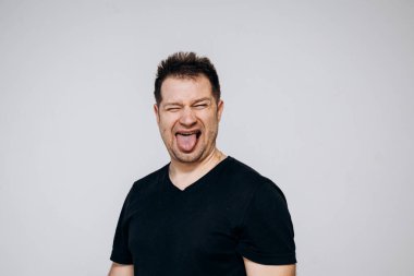 Siyah tişörtlü bir adam etrafta dolanıyor ve kamerada kıvranıyor.