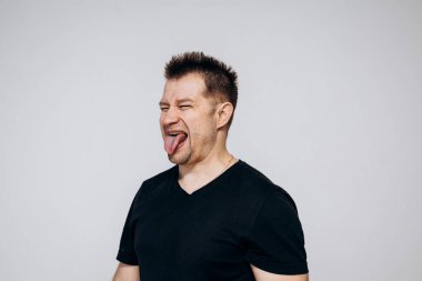 Siyah tişörtlü bir adam etrafta dolanıyor ve kamerada kıvranıyor.