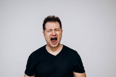 Saldırgan bir adam sinirlenir ve kamerayı yumruğuyla tehdit eder. Üzgün adam.