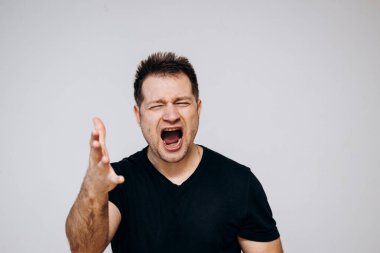 Saldırgan bir adam sinirlenir ve kamerayı yumruğuyla tehdit eder. Üzgün adam.