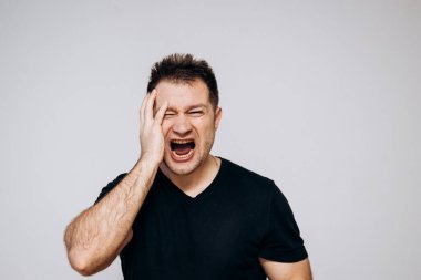 Saldırgan bir adam sinirlenir ve kamerayı yumruğuyla tehdit eder. Üzgün adam.