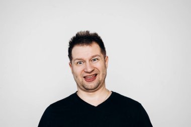 Siyah tişörtlü bir adam etrafta dolanıyor ve kamerada kıvranıyor.