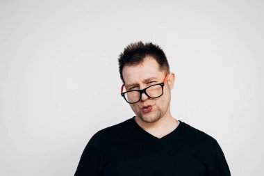 Siyah tişörtlü ve gözlüklü adam düşünüyor ve düşünüyor.