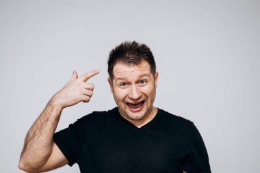 Siyah tişörtlü bir adam etrafta dolanıyor ve kamerada kıvranıyor.