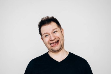 Siyah tişörtlü bir adam etrafta dolanıyor ve kamerada kıvranıyor.