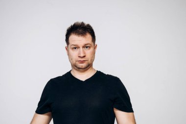 Siyah tişörtlü bir adam etrafta dolanıyor ve kamerada kıvranıyor.