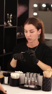 Makyöz işyeri aynanın önünde kaşlarını yapıyor.