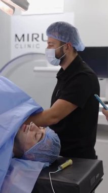 Deneyimli mavi önlüklü cerrahlar hastane ameliyathanesinde askeri bir hastayı ameliyat ederler.