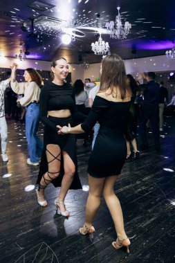 Kharkiv, Ukrayna 15.05.24 kişi bir kulüpte salsa dansı yapıyor. Parlak ışıkları olan bir gece kulübünde sosyal dans.