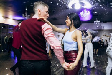 Kharkiv, Ukrayna 15.05.24 kişi bir kulüpte salsa dansı yapıyor. Parlak ışıkları olan bir gece kulübünde sosyal dans.