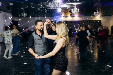 Kharkiv, Ukrayna 15.05.24 kişi bir kulüpte salsa dansı yapıyor. Parlak ışıkları olan bir gece kulübünde sosyal dans.