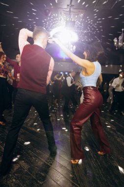 Kharkiv, Ukrayna 15.05.24 kişi bir kulüpte salsa dansı yapıyor. Parlak ışıkları olan bir gece kulübünde sosyal dans.