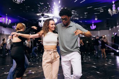 Kharkiv, Ukrayna 15.05.24 kişi bir kulüpte salsa dansı yapıyor. Parlak ışıkları olan bir gece kulübünde sosyal dans.