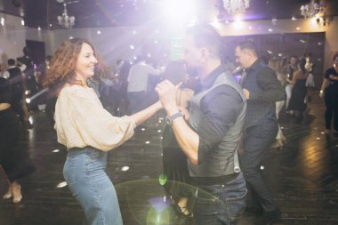 Kharkiv, Ukrayna 15.05.24 kişi bir kulüpte salsa dansı yapıyor. Parlak ışıkları olan bir gece kulübünde sosyal dans.