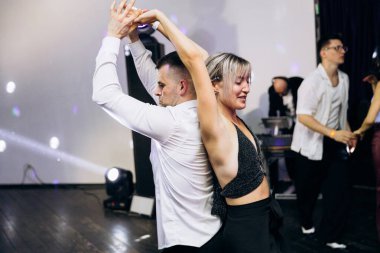 Kharkiv, Ukrayna 15.05.24 kişi bir kulüpte salsa dansı yapıyor. Parlak ışıkları olan bir gece kulübünde sosyal dans.