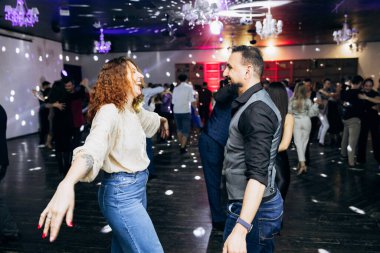 Kharkiv, Ukrayna 15.05.24 kişi bir kulüpte salsa dansı yapıyor. Parlak ışıkları olan bir gece kulübünde sosyal dans.