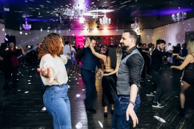 Kharkiv, Ukrayna 15.05.24 kişi bir kulüpte salsa dansı yapıyor. Parlak ışıkları olan bir gece kulübünde sosyal dans.