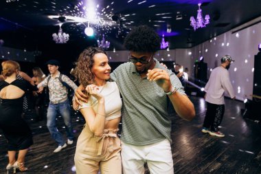Kharkiv, Ukrayna 15.05.24 kişi bir kulüpte salsa dansı yapıyor. Parlak ışıkları olan bir gece kulübünde sosyal dans.