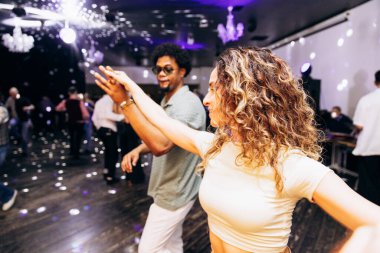 Kharkiv, Ukrayna 15.05.24 kişi bir kulüpte salsa dansı yapıyor. Parlak ışıkları olan bir gece kulübünde sosyal dans.