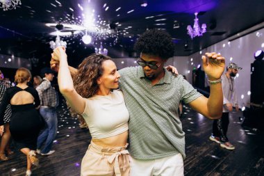 Kharkiv, Ukrayna 15.05.24 kişi bir kulüpte salsa dansı yapıyor. Parlak ışıkları olan bir gece kulübünde sosyal dans.