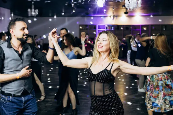 Kharkiv, Ukrayna 15.05.24 kişi bir kulüpte salsa dansı yapıyor. Parlak ışıkları olan bir gece kulübünde sosyal dans.