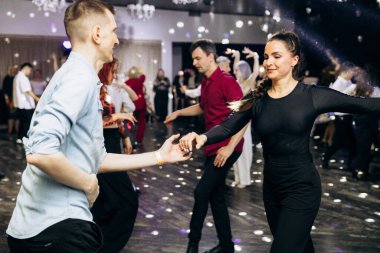 Kharkiv, Ukrayna 15.05.24 kişi bir kulüpte salsa dansı yapıyor. Parlak ışıkları olan bir gece kulübünde sosyal dans.