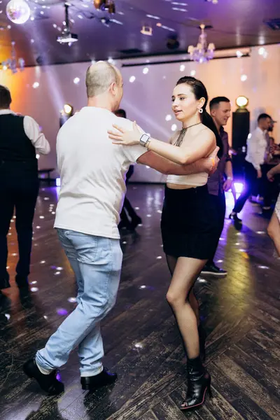 Kharkiv, Ukrayna 15.05.24 kişi bir kulüpte salsa dansı yapıyor. Parlak ışıkları olan bir gece kulübünde sosyal dans.