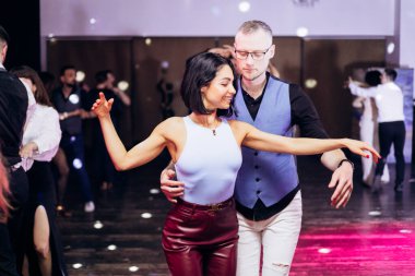 Kharkiv, Ukrayna 15.05.24 kişi bir kulüpte salsa dansı yapıyor. Parlak ışıkları olan bir gece kulübünde sosyal dans.