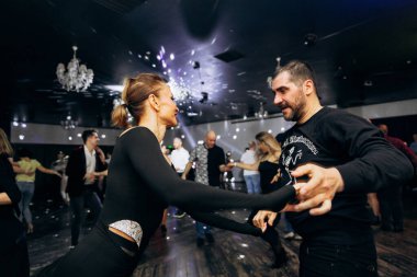 Kharkiv, Ukrayna 15.05.24 kişi bir kulüpte salsa dansı yapıyor. Parlak ışıkları olan bir gece kulübünde sosyal dans.