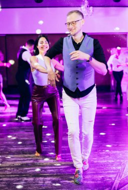 Kharkiv, Ukrayna 15.05.24 kişi bir kulüpte salsa dansı yapıyor. Parlak ışıkları olan bir gece kulübünde sosyal dans.