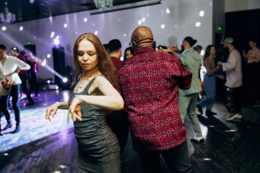 Kharkiv, Ukrayna 15.05.24 kişi bir kulüpte salsa dansı yapıyor. Parlak ışıkları olan bir gece kulübünde sosyal dans.