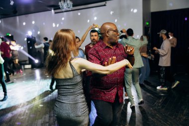 Kharkiv, Ukrayna 15.05.24 kişi bir kulüpte salsa dansı yapıyor. Parlak ışıkları olan bir gece kulübünde sosyal dans.