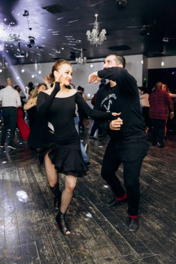Kharkiv, Ukrayna 15.05.24 kişi bir kulüpte salsa dansı yapıyor. Parlak ışıkları olan bir gece kulübünde sosyal dans.