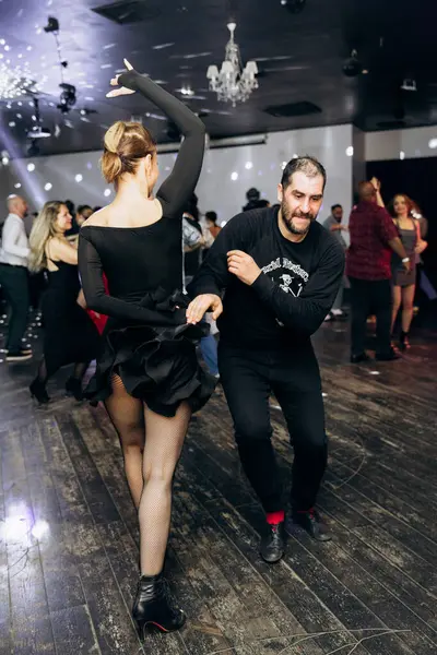 Kharkiv, Ukrayna 15.05.24 kişi bir kulüpte salsa dansı yapıyor. Parlak ışıkları olan bir gece kulübünde sosyal dans.