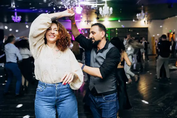 Kharkiv, Ukrayna 15.05.24 kişi bir kulüpte salsa dansı yapıyor. Parlak ışıkları olan bir gece kulübünde sosyal dans.