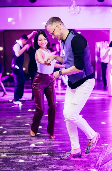 Kharkiv, Ukrayna 15.05.24 kişi bir kulüpte salsa dansı yapıyor. Parlak ışıkları olan bir gece kulübünde sosyal dans.