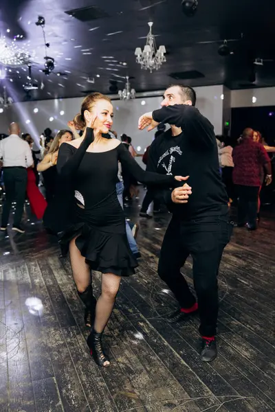 Kharkiv, Ukrayna 15.05.24 kişi bir kulüpte salsa dansı yapıyor. Parlak ışıkları olan bir gece kulübünde sosyal dans.
