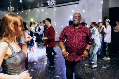 Kharkiv, Ukrayna 15.05.24 kişi bir kulüpte salsa dansı yapıyor. Parlak ışıkları olan bir gece kulübünde sosyal dans.