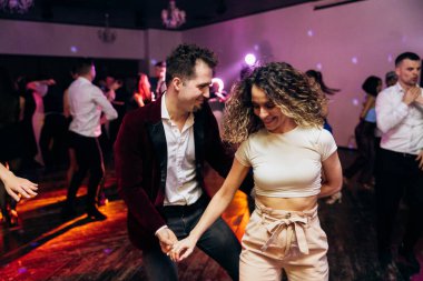 Kharkiv, Ukrayna 15.05.24 kişi bir kulüpte salsa dansı yapıyor. Parlak ışıkları olan bir gece kulübünde sosyal dans.